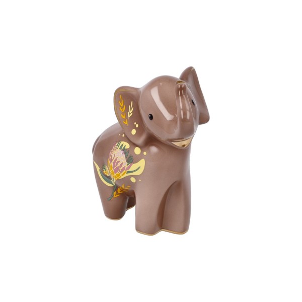 Goebel „Kiombo“ – Elephant de Luxe е изящна порцеланова фигура, вдъхновена от реалния осиротял слон Kiombo, за когото Goebel поема патронаж през 2022 г. Топлите тонове, деликатните растителни мотиви и фините кристални акценти превръщат 15,5-сантиметровата фигура в елегантен символ на сила, мъдрост и надежда. Част от приходите от серията Elephant подкрепят инициативи за защита и грижа за африканските слонове.