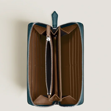 Montblanc Meisterstück Soft Zip-Around Wallet 12CC MB198751 е луксозен портфейл с обикалящ метален цип, произведен в Италия от мека пълнозърнеста телешка кожа. Моделът разполага с 12 отделения за карти, 3 отделения за банкноти, вътрешен джоб с цип за монети и 3 допълнителни джоба. Комбинацията от цвят Dark Pool и кафяв интериор придава модерна визия, а прецизната изработка гарантира комфорт и дълготрайност.