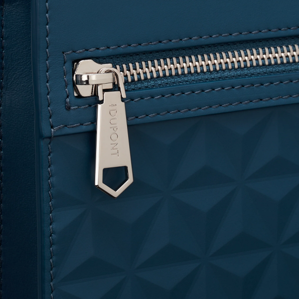 Луксозен клъч S.T. Dupont Apex Pouch Dark Blue, изработен в Италия от гладка пълнозърнеста телешка кожа с отличителна триизмерна интерпретация на емблематичния Fire Head мотив. Дълбокият тъмносин цвят, детайлите с рутениево покритие, светлосивата памучна подплата и практичното разпределение превръщат модела в изискан аксесоар за съвременния мъж.